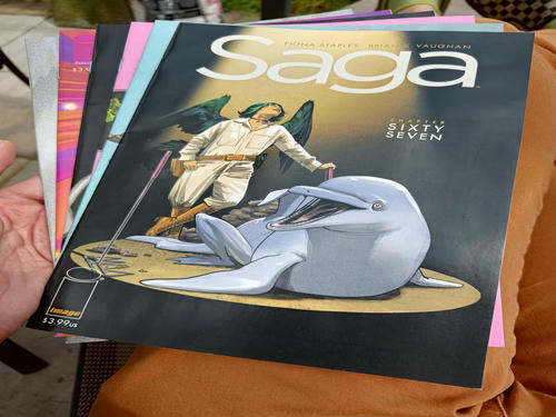 a stack of saga comic books